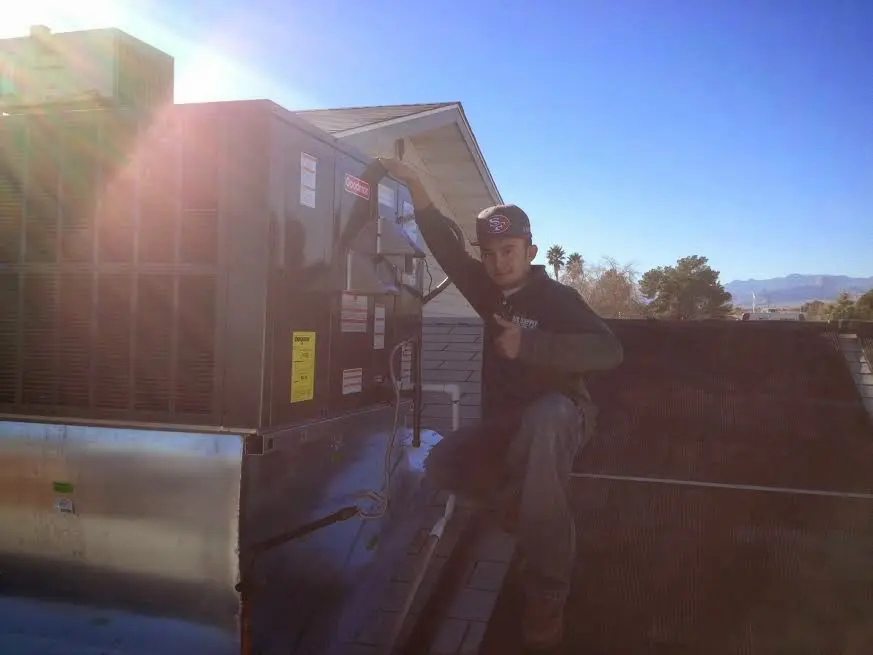 HVAC technician performing Air Duct Repair on a rooftop unit in Kennewick